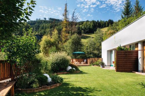 einen Garten mit einem weißen Gebäude und Bäumen in der Unterkunft Annas Garten in Serfaus