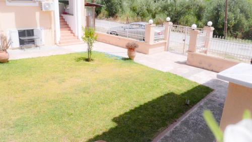 un patio con una valla y un árbol pequeño en Mario's Luxury Maisonette en Neos Marmaras