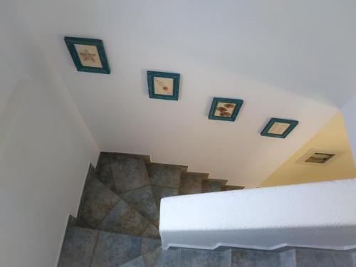 a staircase with pictures on the wall and a stair case at Mario's Luxury Maisonette in Neos Marmaras