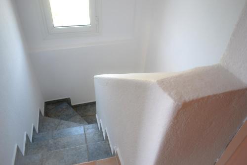 a stairway with a window in a white wall at Mario's Luxury Maisonette in Neos Marmaras