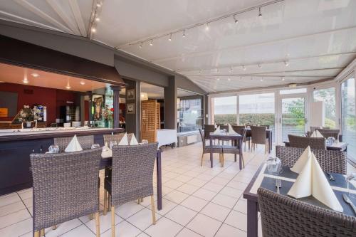 un restaurant avec des tables, des chaises et un comptoir dans l'établissement Comfort Hotel Lille L'Union, à Tourcoing