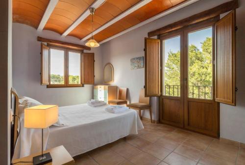 サン・ホルヘにあるMas dels Estellersの窓付きの部屋にベッド付きのベッドルーム1室があります。