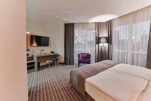 ein Hotelzimmer mit einem Bett und einem Schreibtisch in der Unterkunft Boutique Hotel Central in Riwne