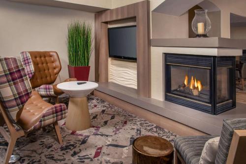 a living room with a fireplace and a tv at Sonesta ES Suites Baltimore BWI Airport in Linthicum Heights