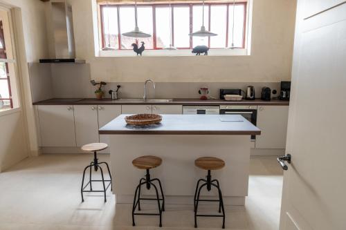 a kitchen with a counter and two stools at Gite de Vonnes in Pont-de-Ruan