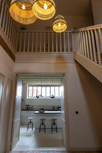 un couloir avec une table, deux tabourets et deux lumières dans l'établissement Gite de Vonnes, à Pont-de-Ruan