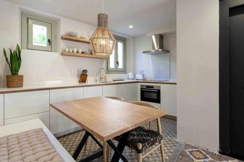 una cucina con tavolo e sedie in legno di Velo Vern 2 Luxury apartment in the Old Town a Girona