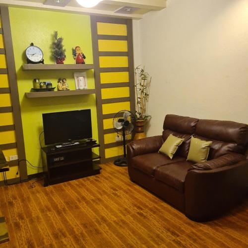 a living room with a couch and a tv at 722 Metropolis Tower Unit 212 in Bacolod