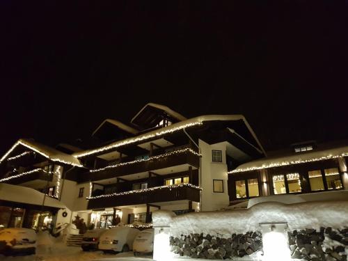 a building covered in snow at night with lights at Seehotel Hartung & Ferienappartements in Füssen