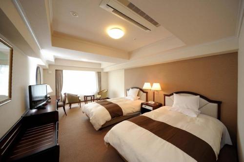 A bed or beds in a room at Imabari Kokusai Hotel