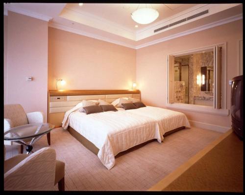 a bedroom with a large bed and a window at Imabari Kokusai Hotel in Imabari