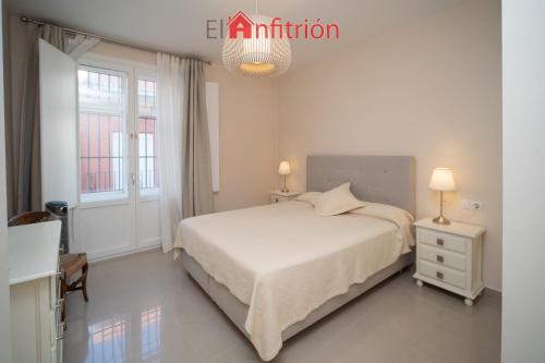 - une chambre blanche avec un lit et 2 fenêtres dans l'établissement Araucaria Home, à Sanlúcar de Barrameda