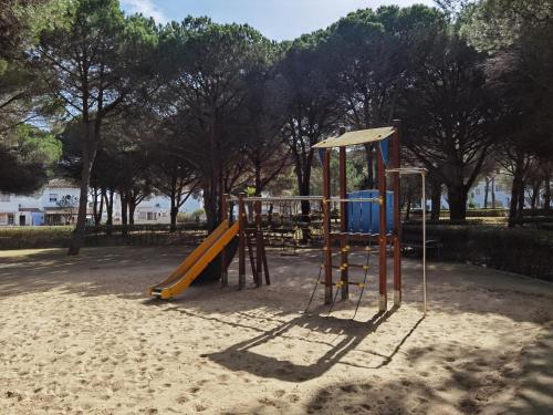ein Spielplatz mit Rutsche in einem Park in der Unterkunft LA BARROSA-NOVO SANCTI PETRI, wifi, aire acondicionado, parking in Chiclana de la Frontera