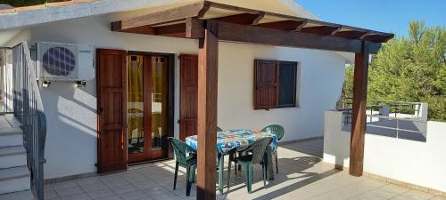 a patio with a table and chairs on a balcony at Stefania Apartments in Porto Pino