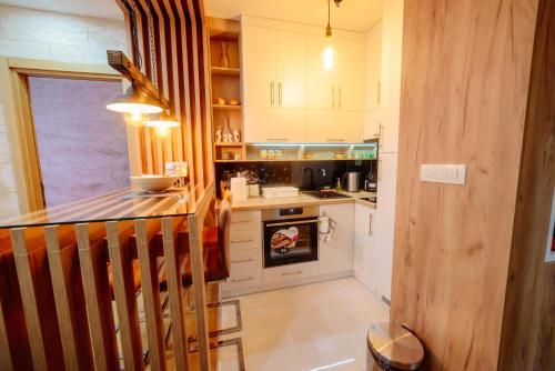 a kitchen with white cabinets and a stove top oven at Balkan Hill Zlatibor in Zlatibor