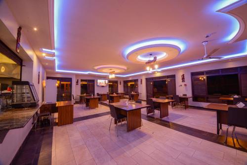 Un restaurante con mesas y sillas en una habitación. en Mlex Hotel, en Kampala