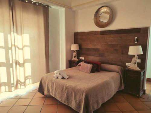 sypialnia z dużym łóżkiem i lustrem w obiekcie Palacio Doñana , Rural & Luxury w mieście El Rocío