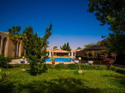 a house with a yard with a swimming pool at Hotel Monotel Dar El Barka in Nouakchott