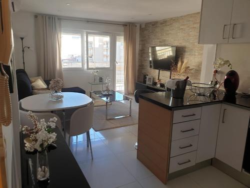 a kitchen and living room with a table and a couch at Apartmento de 3 habitaciones con vistas al mar in Playa de Gandia