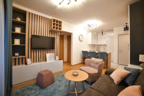 a living room with a couch and a tv and a table at Balkan Hill Zlatibor in Zlatibor