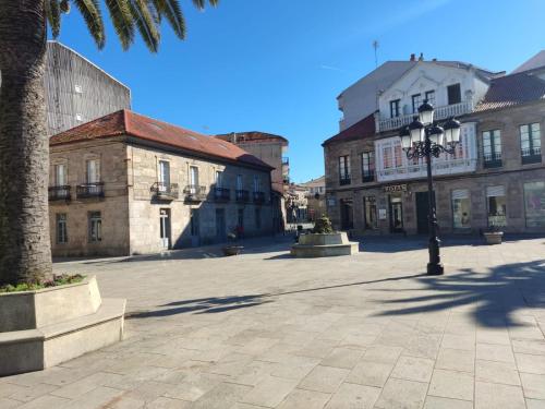 a city street with buildings and a palm tree at Hotel Herbiña in Cambados