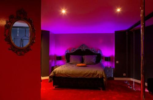 - une chambre dotée d'un lit avec des lumières violettes dans l'établissement SUITE PLAYROOM Love Hotel Toulouse, à Toulouse
