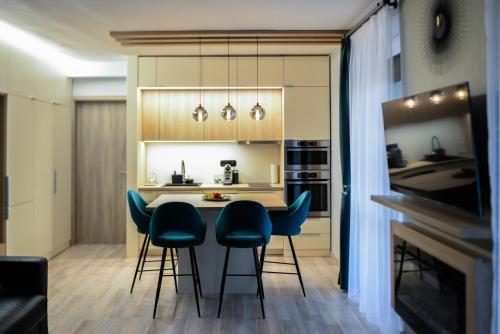 a kitchen with a table and some blue chairs at Nekem Füred in Balatonfüred