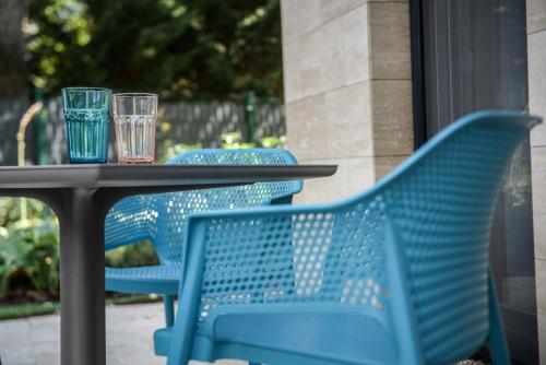 a table with blue chairs and glasses on it at Nekem Füred in Balatonfüred