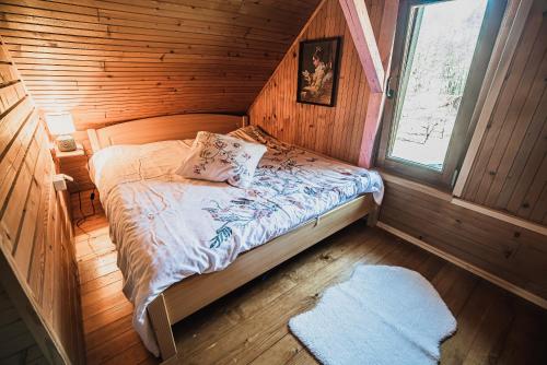 a bedroom with a bed in a wooden cabin at Wooden Cabin Zurej with Hot Tub in Bukovje v Babni Gori
