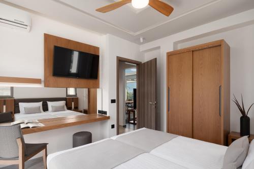 a bedroom with two beds and a desk and a tv at Agrielia Villas, featuring Heated Spa Whirlpool, By ThinkVilla in Pigianos Kampos