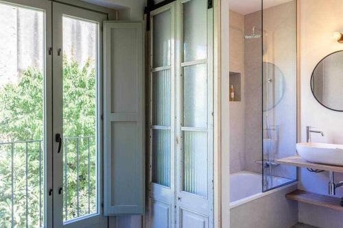 bagno con vasca, lavandino e finestra di Velo Vern 3 Luxury penthouse w views of city wall a Girona