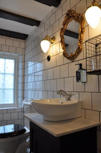 a bathroom with a sink and a mirror on the wall at Hotell Hamngatan 27 in Falkenberg