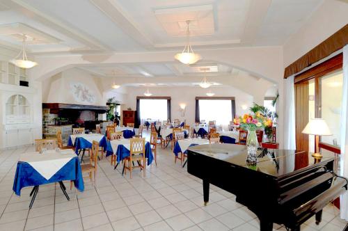a restaurant with a grand piano and tables and chairs at Toscana Wellness Resort in Arcidosso