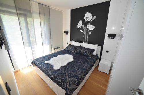 a bedroom with a bed with a flower on the wall at Balkan Hill Zlatibor in Zlatibor