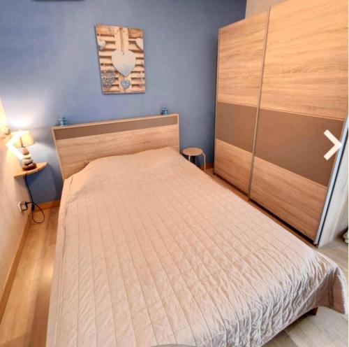 une chambre avec un lit avec une tête de lit en bois dans l'établissement Gîtes Saint Julien, à Argelès-sur-Mer