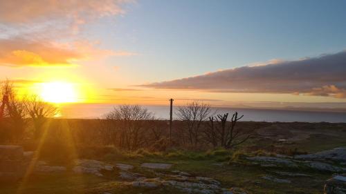 a sunset over the ocean with the sun setting at Y Branwen Restaurant & Rooms - Adult Only and Dog Friendly in Harlech