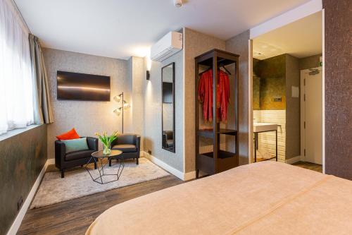 a hotel room with a bed and a chair at Fly Rooms Madrid Airport in Madrid