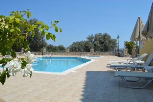 a swimming pool with chaise lounge chairs next to at Argyro Villa in Balíon
