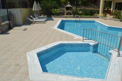 a large swimming pool with a tile floor at Argyro Villa in Balíon
