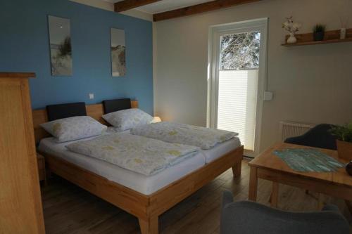 a bedroom with a bed and a table and a window at Ferienwohnungen Heideidylle in Amelinghausen