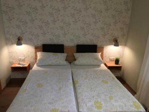 a bedroom with two beds and two tables with lamps at Ferienwohnungen Heideidylle in Amelinghausen