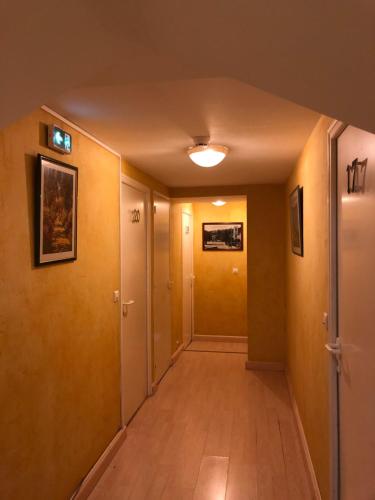 an empty hallway with yellow walls and wooden floors at Hostellerie Au rendez-vous des amis in Chaumont