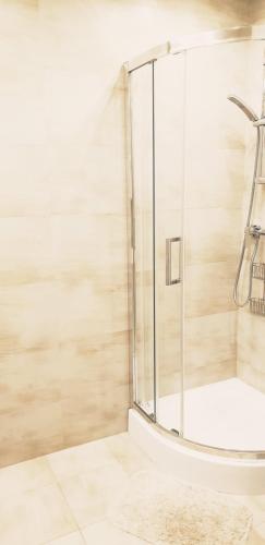 a bathroom with a shower with a glass at Studio City centre Lutomierska Manufaktura in Łódź