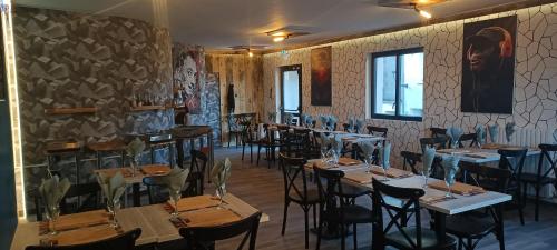 une salle avec des tables et des chaises dans un restaurant dans l'établissement Gîte de La Bicyclette, à Montournais