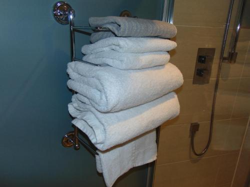 een stel handdoeken hangend aan een handdoekenrek in de badkamer bij Dreamwood Cottage, Loch Lomond, Luxury Apartment. in Glasgow