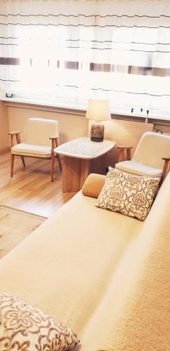 a bedroom with a bed and two chairs and a table at Studio City centre Lutomierska Manufaktura in Łódź