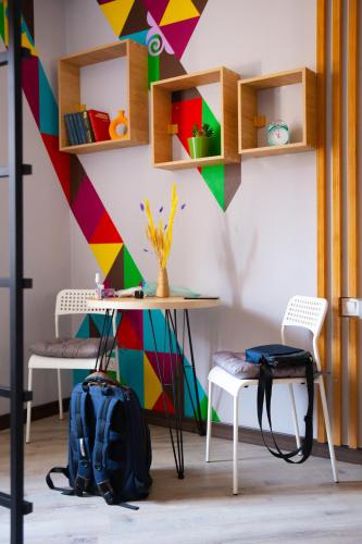 a room with a table and chairs and a colorful wall at People Hostel in Bishkek