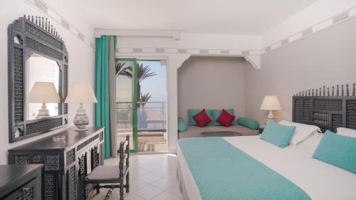 ein Schlafzimmer mit einem Bett und ein Wohnzimmer in der Unterkunft Agadir Beach Club in Agadir