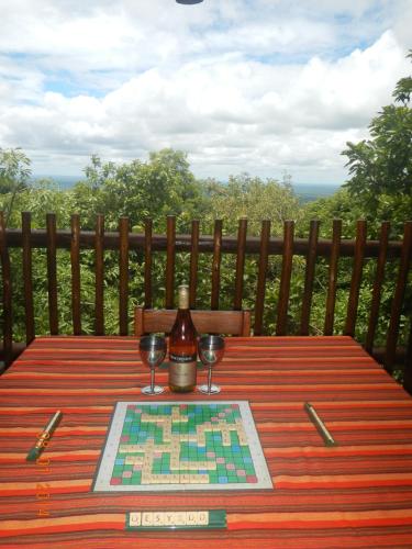 a wooden table with a bottle of wine and two glasses at Amafu Forest Lodge in Hoedspruit