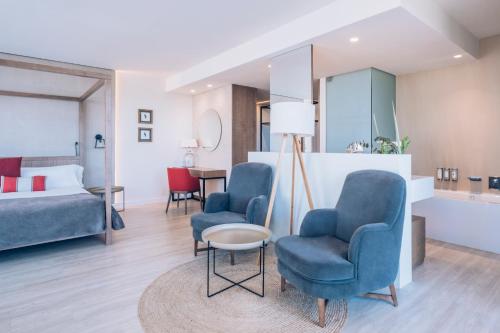 a hotel room with two chairs and a bed at Iberostar Selection Llaut Palma- Adults Only in Playa de Palma